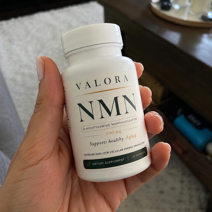 A VALORA customer holding her NMN bottle