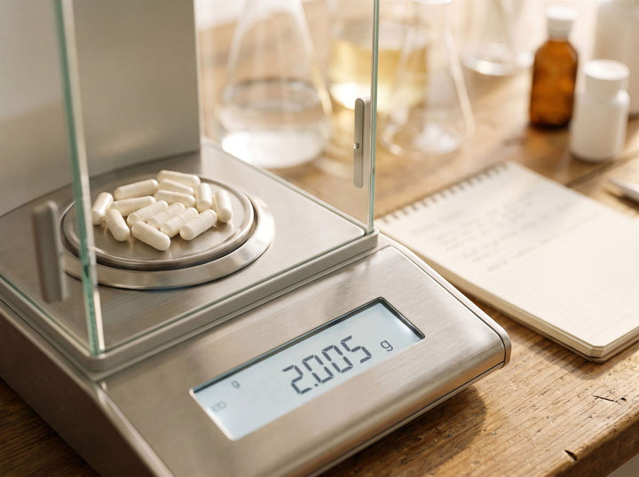 White capsules on a precision lab scale