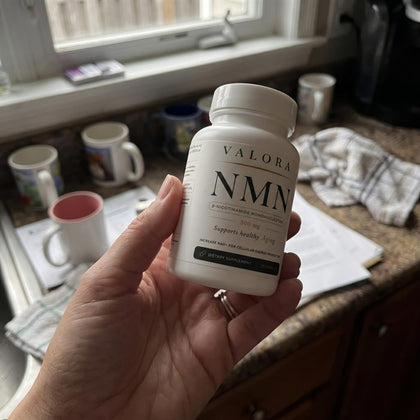 A VALORA customer holding her NMN bottle