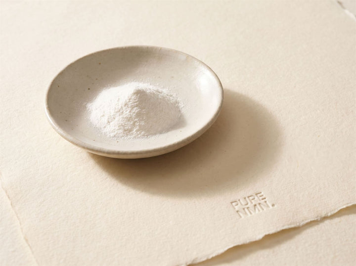 A ceramic dish of fine white NMN powder